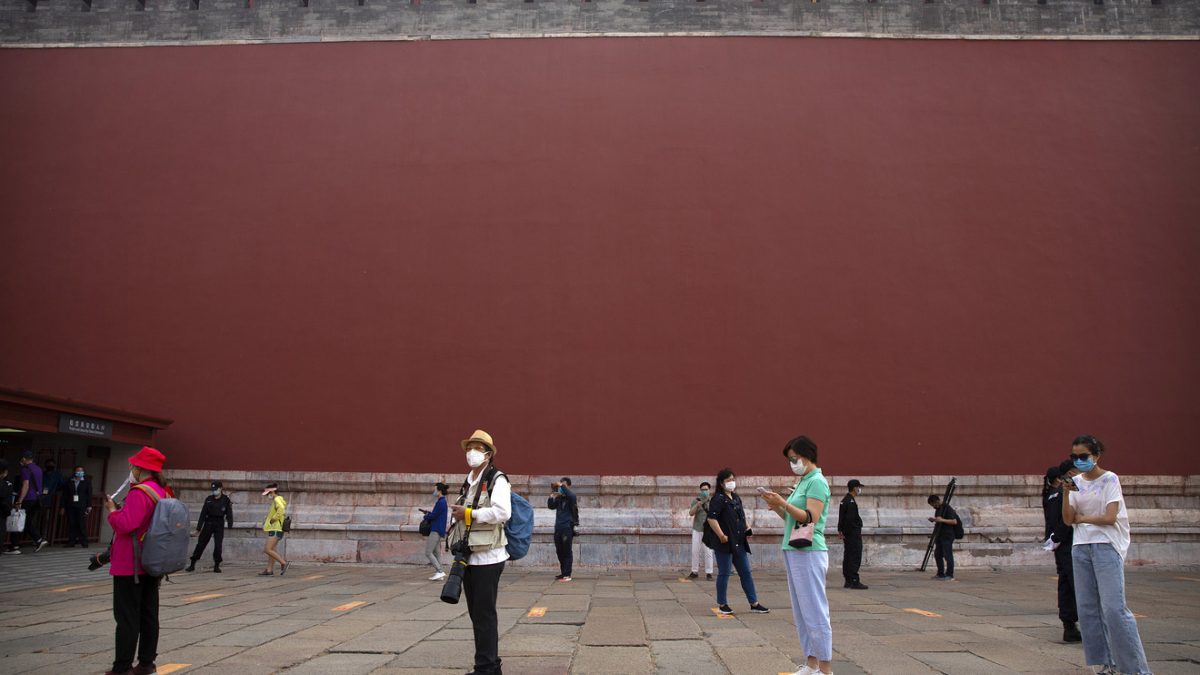 Visitors wearing face masks to protect against the new coronavirus stand widely spaced in line as they wait to enter the Forbidden City in Beijing, May 1, 2020. The Forbidden City reopened on Friday, China's May Day holiday, to limited visitors after being closed to the public for more than three months during the coronavirus outbreak.